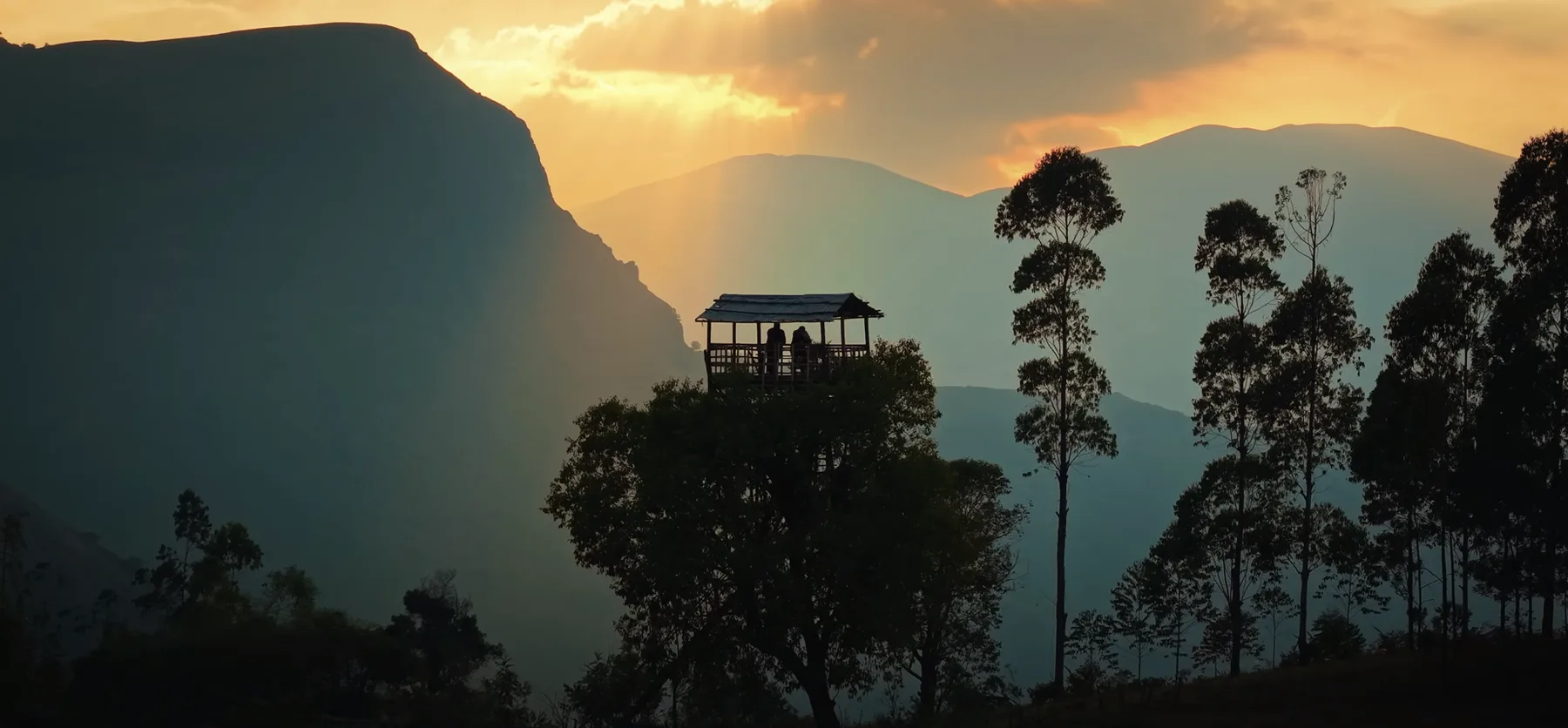 A hilltop viewing shelter silhouetted against a Kanthalloor sunset