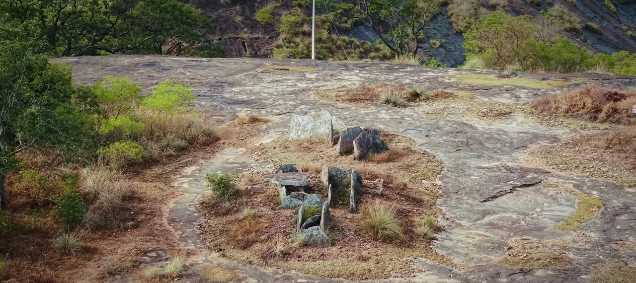 A group of ancient stone dolmens on a rocky Marayoor hillside